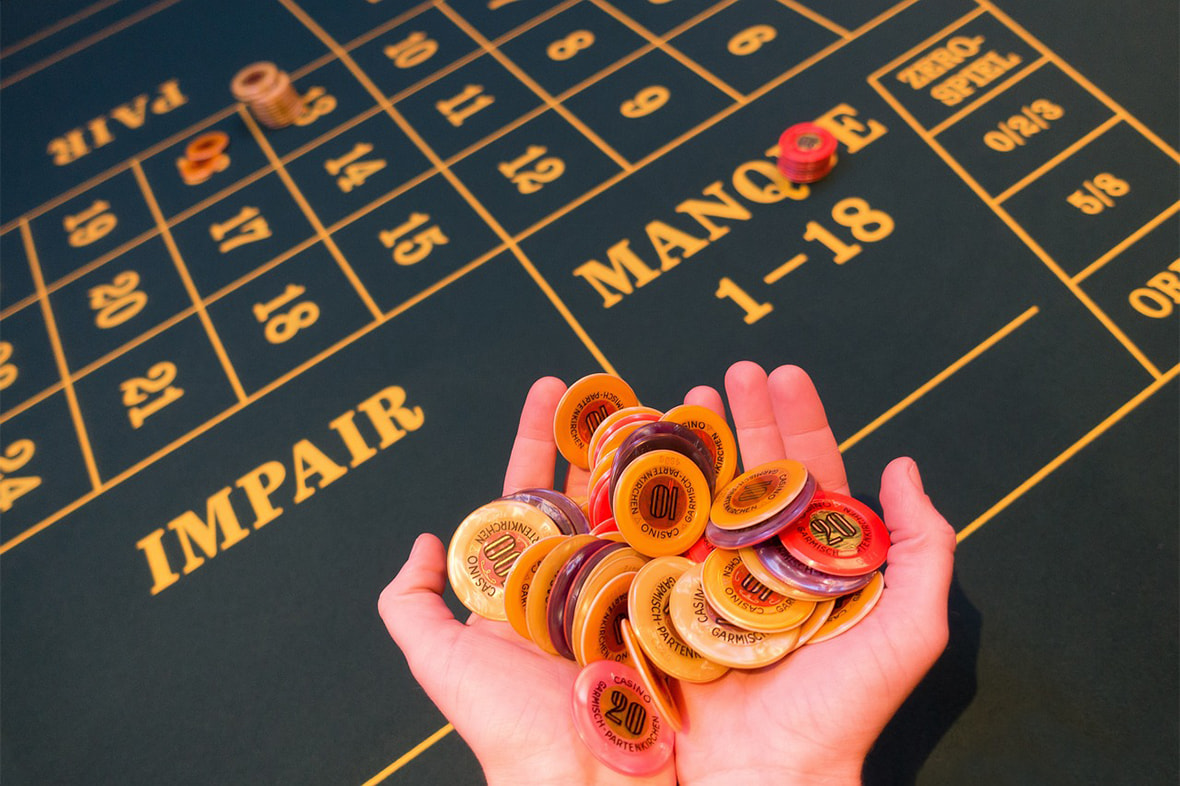 Person holding chips at the roulette table 