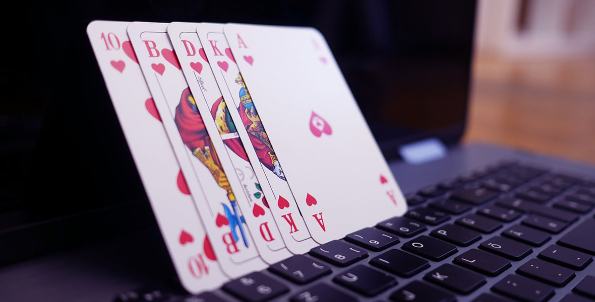 Playing cards rested on a laptop 