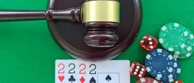 A Judge's Gavel, Playing Cards, and Poker Chips on a Gaming Table.