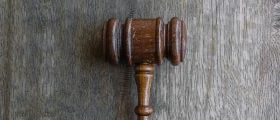 A Brown judge Mallet on a Grey Wooden Sesk